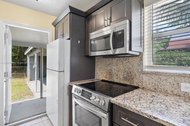 602 El Prado, West Palm Beach, FL 33405 - kitchen with stainless steel appliances, plenty of natural light, tasteful backsplash, and light tile patterned flooring