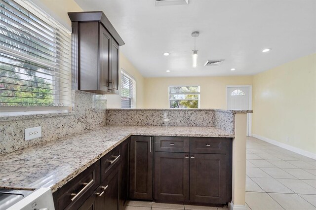 602 El Prado, West Palm Beach, FL 33405 - kitchen featuring a peninsula, light tile patterned flooring, dark brown cabinets, backsplash, and recessed lighting