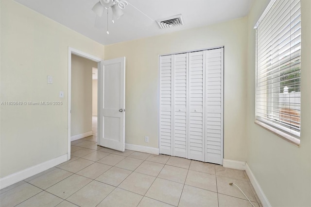 602 El Prado, West Palm Beach, FL 33405 - unfurnished bedroom with light tile patterned flooring, a closet, and a ceiling fan