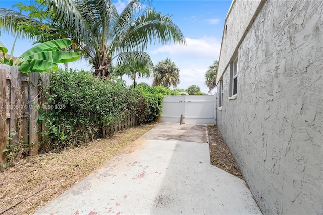 602 El Prado, West Palm Beach, FL 33405 - fenced backyard with a gate, concrete driveway, and a patio