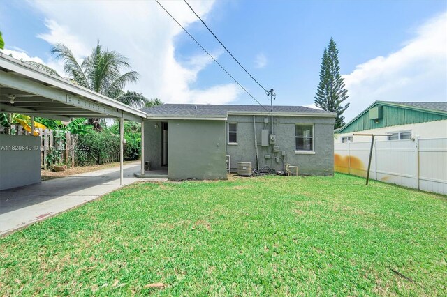 602 El Prado, West Palm Beach, FL 33405 - rear view of house featuring stucco siding, concrete driveway, and a carport