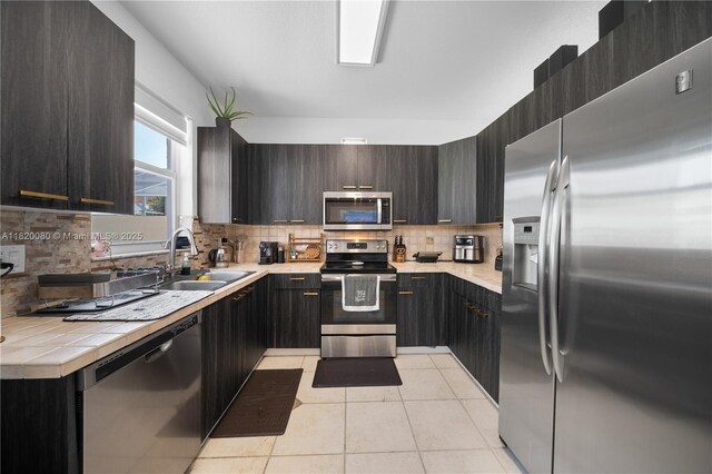 15872 NW 21st St, Pembroke Pines, FL 33028 - kitchen featuring appliances with stainless steel finishes, light tile patterned floors, backsplash, tile counters, and modern cabinets