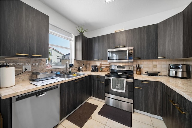 15872 NW 21st St, Pembroke Pines, FL 33028 - kitchen featuring appliances with stainless steel finishes, tasteful backsplash, light tile patterned floors, and tile counters