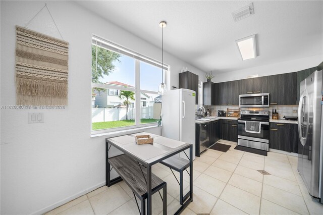 15872 NW 21st St, Pembroke Pines, FL 33028 - kitchen with appliances with stainless steel finishes, light countertops, backsplash, light tile patterned floors, and pendant lighting