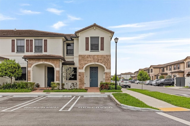 3411 W 112th Ter, Hialeah, FL 33018 - multi unit property featuring stone siding, uncovered parking, stucco siding, a tile roof, and a residential view