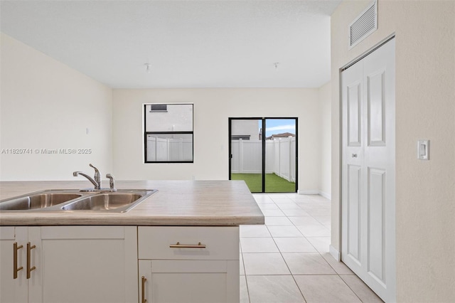 3411 W 112th Ter, Hialeah, FL 33018 - kitchen featuring white cabinetry, light tile patterned floors, light countertops, and open floor plan