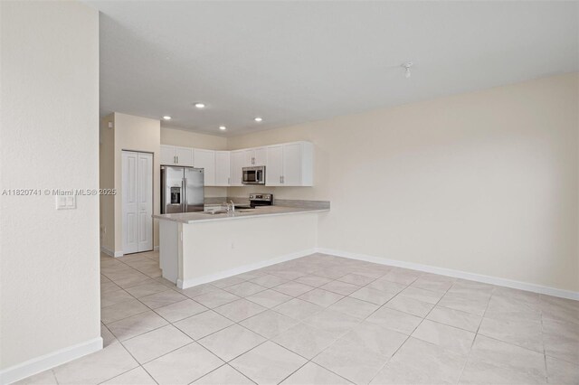 3411 W 112th Ter, Hialeah, FL 33018 - kitchen with appliances with stainless steel finishes, white cabinetry, light countertops, a peninsula, and recessed lighting