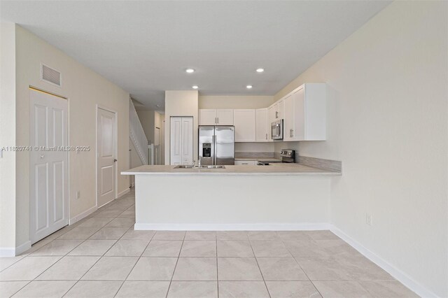 3411 W 112th Ter, Hialeah, FL 33018 - kitchen featuring appliances with stainless steel finishes, a peninsula, light countertops, white cabinetry, and light tile patterned flooring