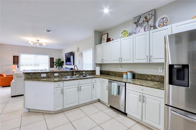 148 NE 36th Avenue Rd, Homestead, FL 33033 - kitchen featuring appliances with stainless steel finishes, a peninsula, white cabinetry, open floor plan, and dark stone counters