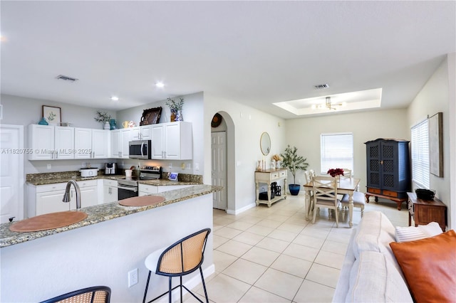 148 NE 36th Avenue Rd, Homestead, FL 33033 - kitchen featuring stainless steel appliances, light tile patterned flooring, a raised ceiling, white cabinets, and light stone countertops