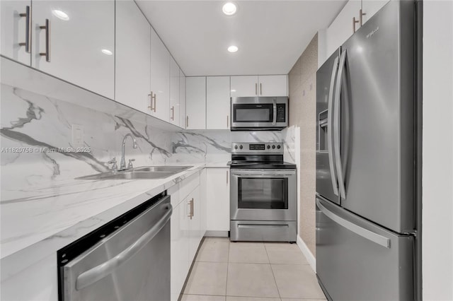 14388 SW 96th Ln, Miami, FL 33186 - kitchen featuring appliances with stainless steel finishes, white cabinetry, light tile patterned flooring, backsplash, and light stone counters