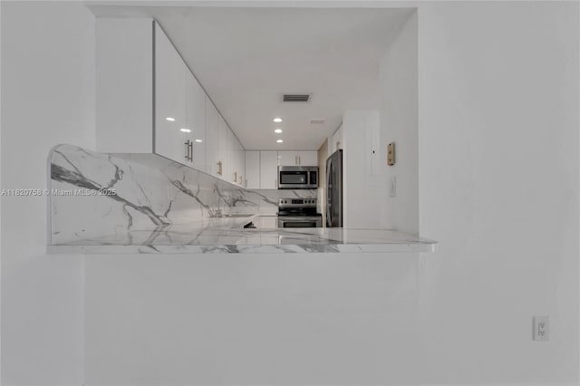 14388 SW 96th Ln, Miami, FL 33186 - kitchen featuring stainless steel appliances, decorative backsplash, white cabinetry, recessed lighting, and a peninsula