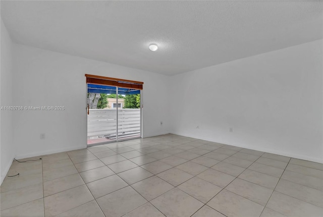 14388 SW 96th Ln, Miami, FL 33186 - spare room featuring a textured ceiling and light tile patterned floors