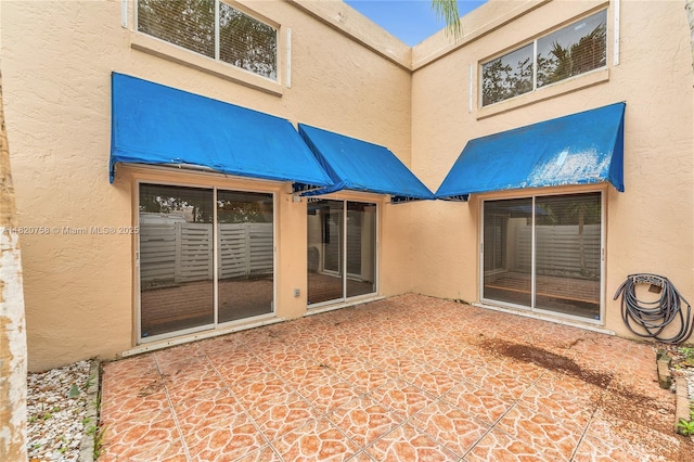 14388 SW 96th Ln, Miami, FL 33186 - rear view of house with stucco siding and a patio area