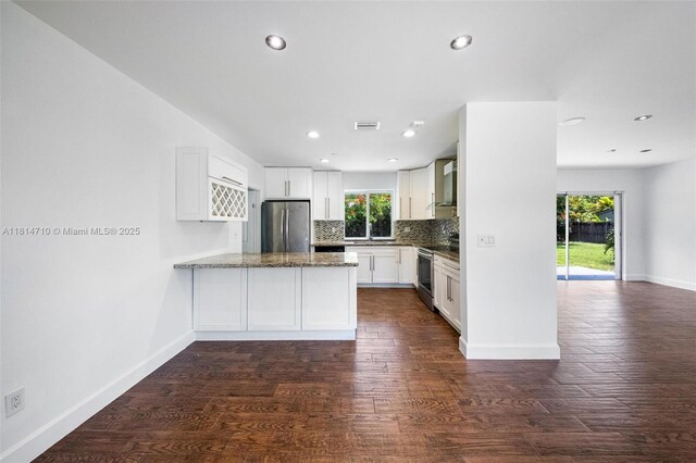 9221 SW 167th Ter, Palmetto Bay, FL 33157 - kitchen with appliances with stainless steel finishes, a peninsula, decorative backsplash, white cabinetry, and dark wood-style flooring