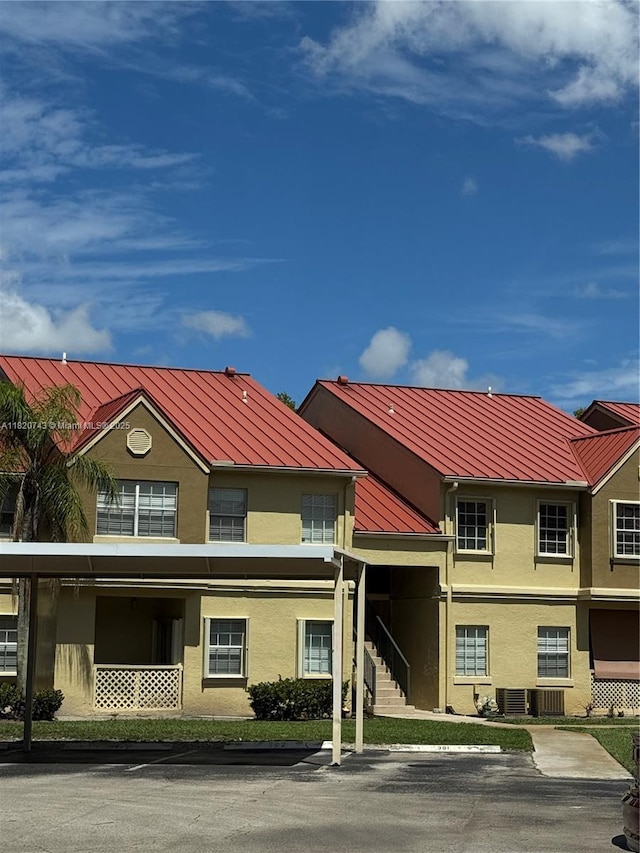 18346 NW 68th Ave Unit K, Hialeah, FL 33015 - view of property featuring covered and uncovered parking and stairs