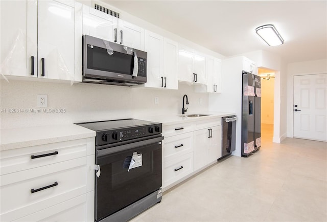 1750 NE 191st St Unit 100-1, Miami, FL 33179 - kitchen featuring black appliances, light countertops, and white cabinets