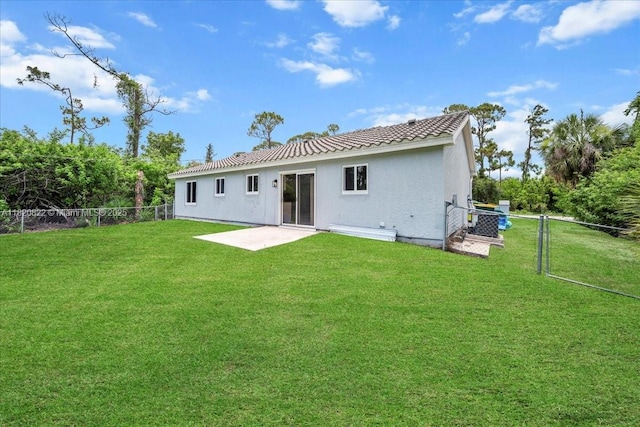 18125 Wintergarden Ave, Port Charlotte, FL 33948 - back of house with a fenced backyard, stucco siding, a tiled roof, and a patio area