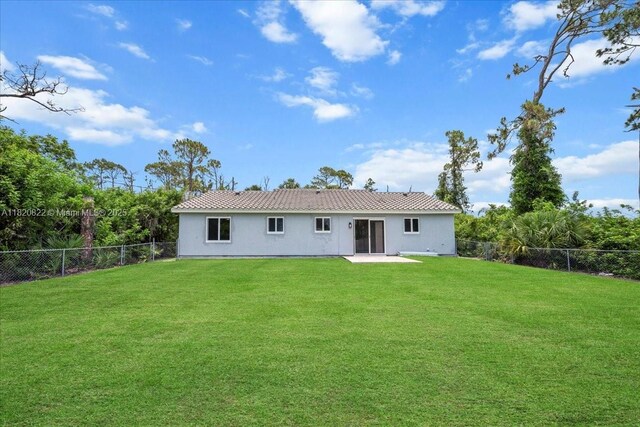 18125 Wintergarden Ave, Port Charlotte, FL 33948 - back of property featuring a fenced backyard, stucco siding, and a patio area