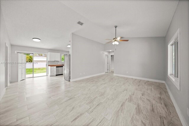 18125 Wintergarden Ave, Port Charlotte, FL 33948 - unfurnished living room with ceiling fan and vaulted ceiling