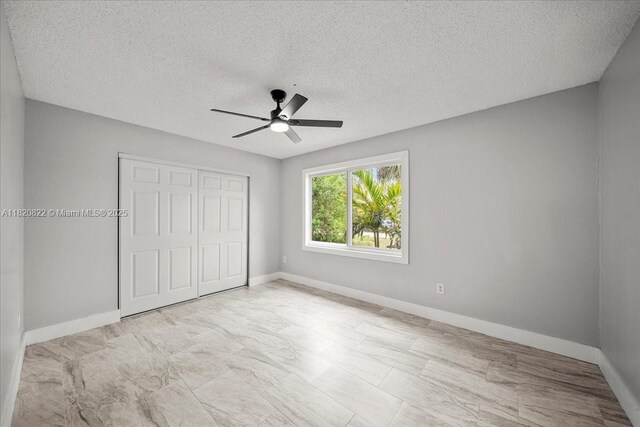 18125 Wintergarden Ave, Port Charlotte, FL 33948 - unfurnished bedroom featuring a closet, a textured ceiling, and a ceiling fan