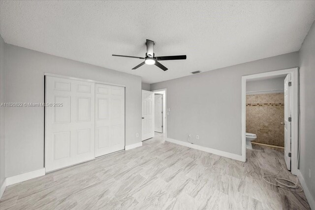18125 Wintergarden Ave, Port Charlotte, FL 33948 - unfurnished bedroom featuring a closet, ensuite bath, a textured ceiling, and a ceiling fan