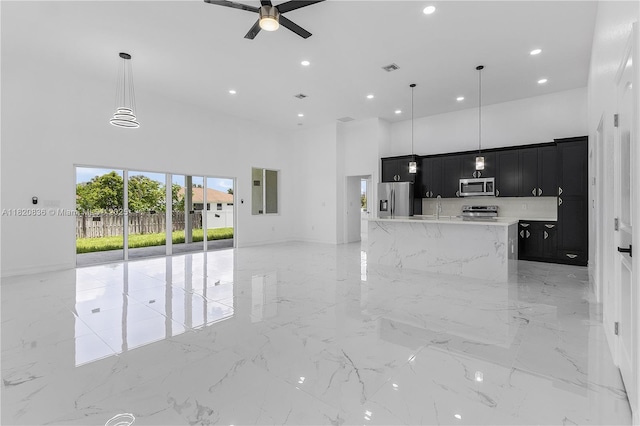 3510 2nd St W, Lehigh Acres, FL 33971 - kitchen featuring stainless steel appliances, dark cabinets, a high ceiling, open floor plan, and ceiling fan