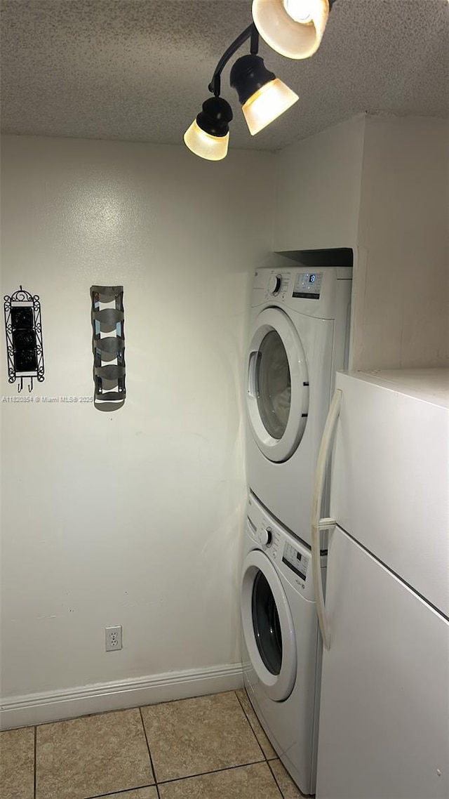953 Coral Club Dr Unit 953, Coral Springs, FL 33071 - washroom featuring stacked washer and clothes dryer, light tile patterned flooring, and a textured ceiling