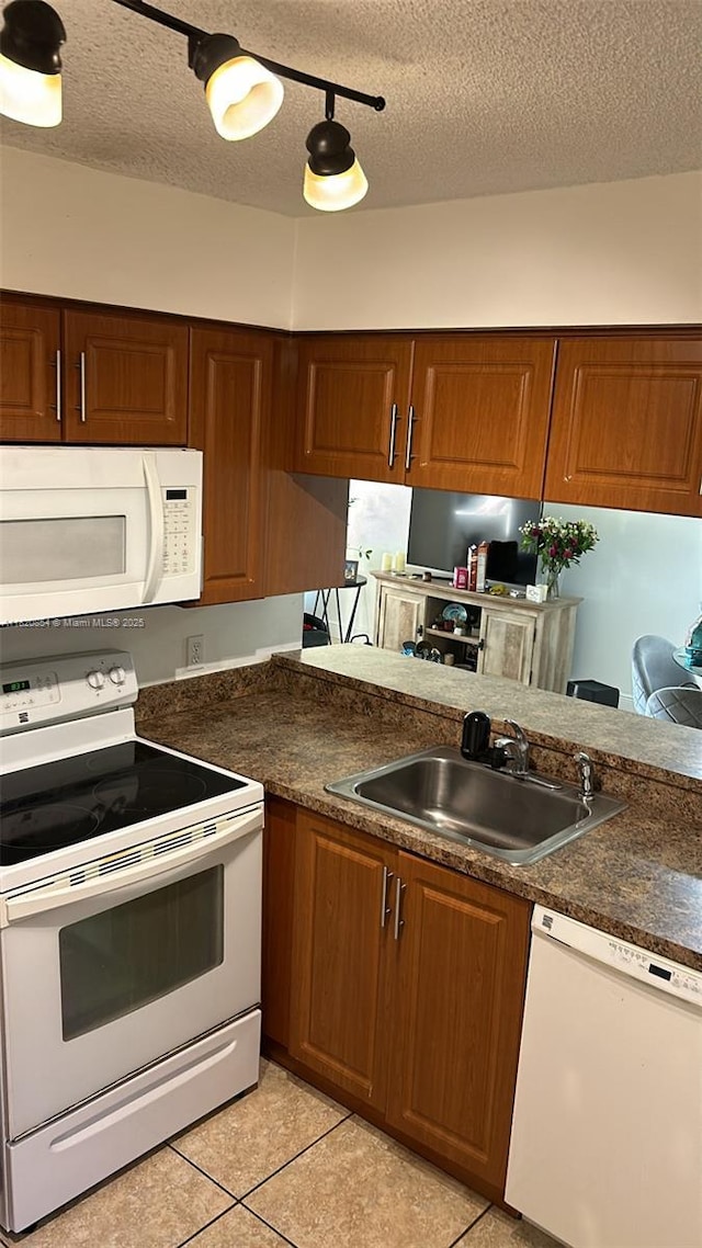 953 Coral Club Dr Unit 953, Coral Springs, FL 33071 - kitchen featuring white appliances, light tile patterned flooring, a textured ceiling, dark countertops, and brown cabinets