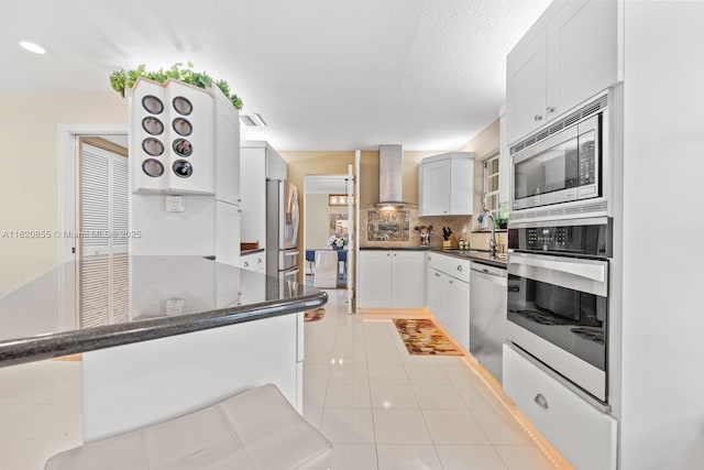 12821 SW 148th St Rd, Miami, FL 33186 - kitchen with appliances with stainless steel finishes, wall chimney exhaust hood, backsplash, light tile patterned floors, and a textured ceiling
