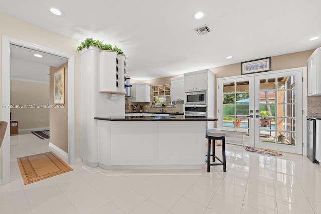 12821 SW 148th St Rd, Miami, FL 33186 - kitchen featuring appliances with stainless steel finishes, backsplash, recessed lighting, dark countertops, and light tile patterned floors