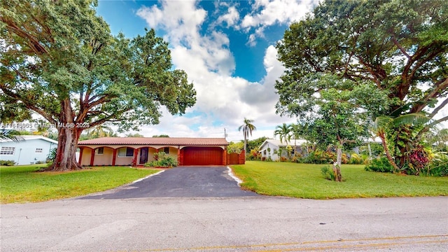2116 NW 3rd Ave, Wilton Manors, FL 33311 - view of front of home featuring a garage, asphalt driveway, a tiled roof, and a front lawn