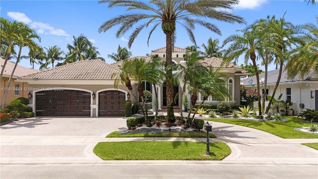 10985 Canary Island Ct, Plantation, FL 33324 - mediterranean / spanish home featuring decorative driveway, an attached garage, a tiled roof, and stucco siding