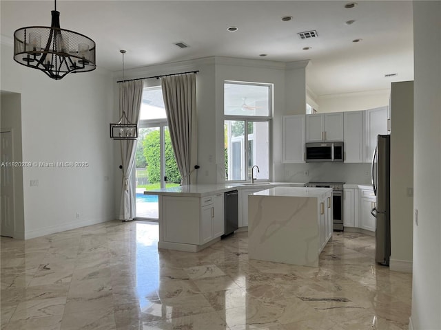 1290 Ginger Cir, Weston, FL 33326 - kitchen with stainless steel appliances, a kitchen island, a chandelier, light marble finish flooring, and ornamental molding