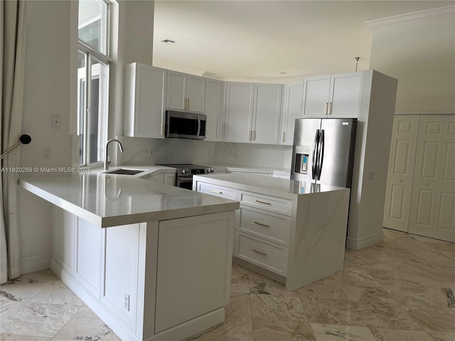 1290 Ginger Cir, Weston, FL 33326 - kitchen featuring appliances with stainless steel finishes, a peninsula, light marble finish floors, light countertops, and white cabinetry