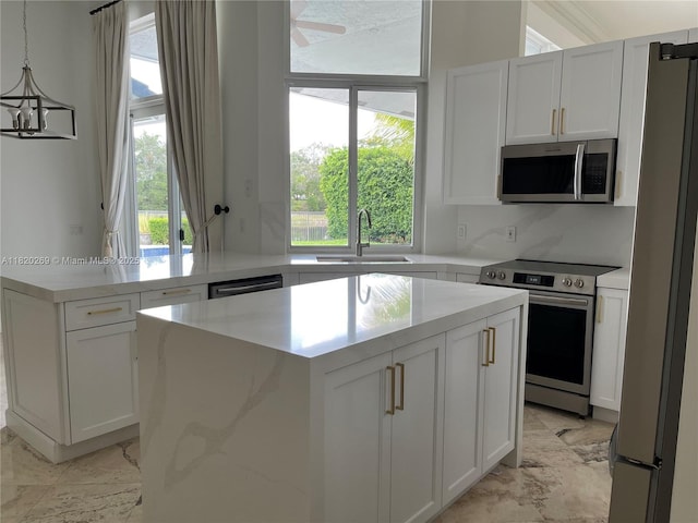 1290 Ginger Cir, Weston, FL 33326 - kitchen with stainless steel appliances, light marble finish flooring, a center island, and white cabinets