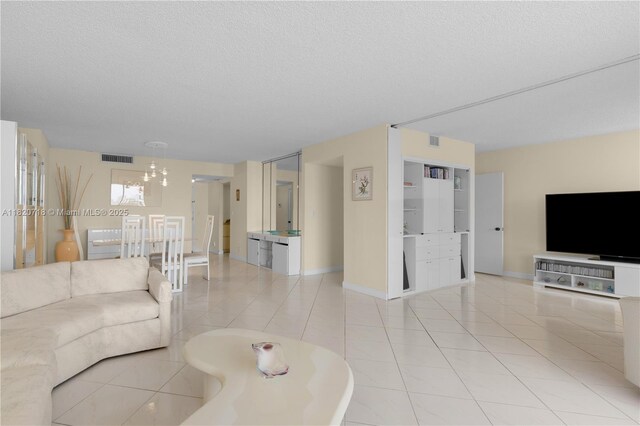 2500 Parkview Dr Unit 1717, Hallandale Beach, FL 33009 - living room with a chandelier, a textured ceiling, and tile patterned flooring
