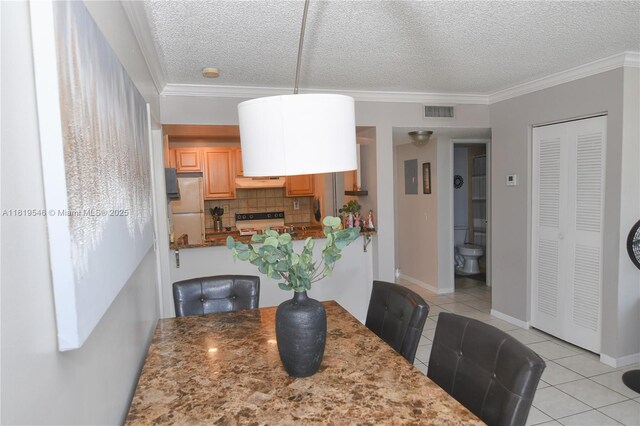 7125 NW 186th St Unit B311, Hialeah, FL 33015 - dining room with light tile patterned flooring, a textured ceiling, and crown molding