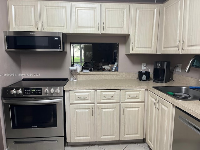 2900 Fiore Way Unit 1080, Delray Beach, FL 33445 - kitchen featuring appliances with stainless steel finishes, light countertops, and light tile patterned floors