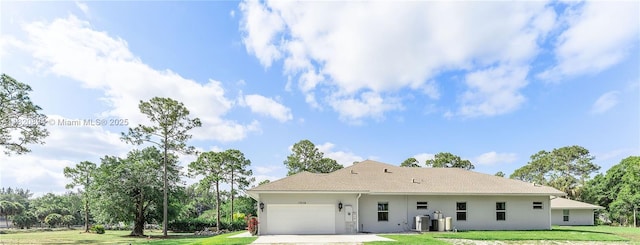 17038 N 61st Pl N, Loxahatchee, FL 33470 - rear view of house featuring an attached garage, a yard, driveway, stucco siding, and roof with shingles
