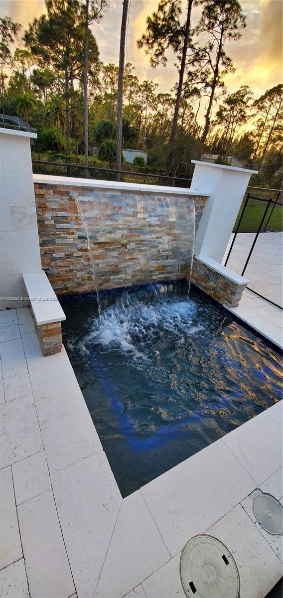17038 N 61st Pl N, Loxahatchee, FL 33470 - pool at dusk featuring an in-ground hot tub