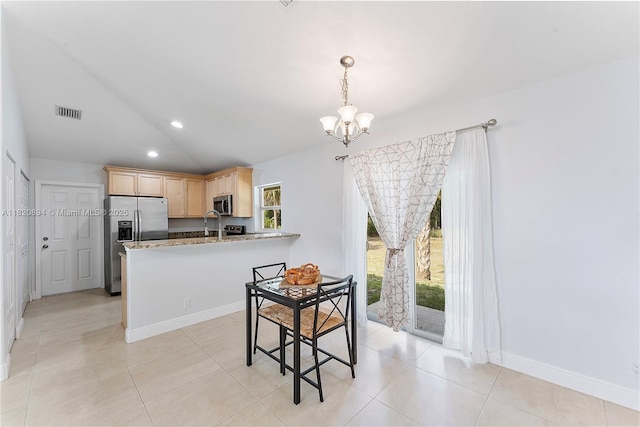 17038 N 61st Pl N, Loxahatchee, FL 33470 - kitchen with stainless steel appliances, light brown cabinetry, lofted ceiling, a chandelier, and healthy amount of natural light