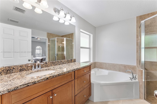 17038 N 61st Pl N, Loxahatchee, FL 33470 - full bath featuring a stall shower, vanity, a garden tub, tile patterned flooring, and a textured ceiling