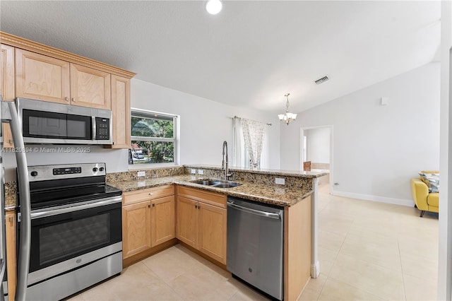 17038 N 61st Pl N, Loxahatchee, FL 33470 - kitchen with appliances with stainless steel finishes, a peninsula, a chandelier, vaulted ceiling, and light brown cabinets