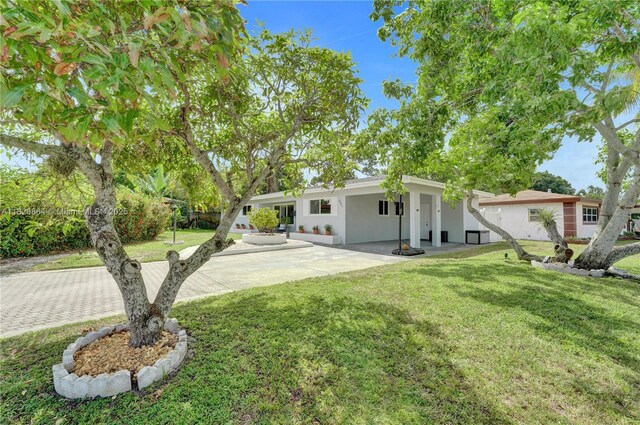 651 E Evanston Cir, Fort Lauderdale, FL 33312 - view of front facade featuring stucco siding, a front yard, and a patio area