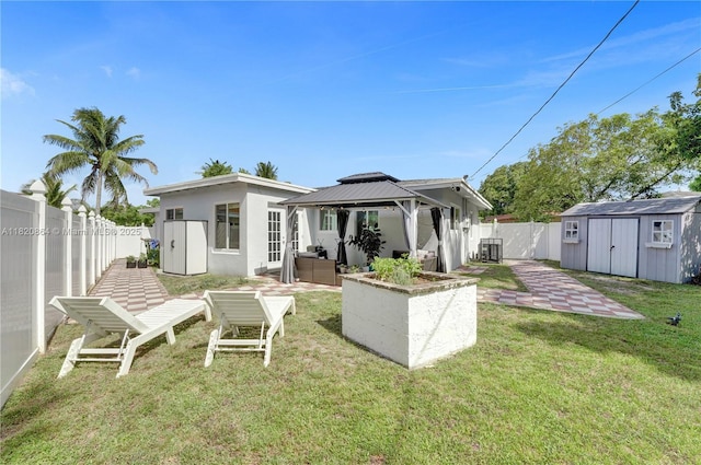 651 E Evanston Cir, Fort Lauderdale, FL 33312 - back of house featuring a storage unit, a gazebo, a fenced backyard, a patio, and stucco siding