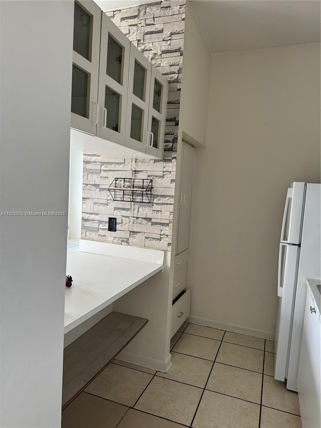 7400 W 20th Ave Unit 416, Hialeah, FL 33016 - kitchen with freestanding refrigerator, light tile patterned floors, glass insert cabinets, light countertops, and white cabinets