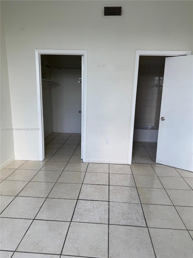 7400 W 20th Ave Unit 416, Hialeah, FL 33016 - unfurnished bedroom with light tile patterned floors, a spacious closet, and a closet