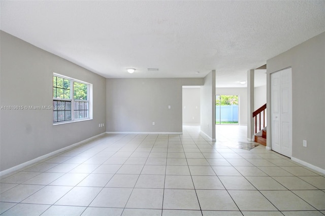 9741 SW 12th St, Pembroke Pines, FL 33025 - unfurnished room featuring plenty of natural light, stairway, light tile patterned flooring, and a textured ceiling