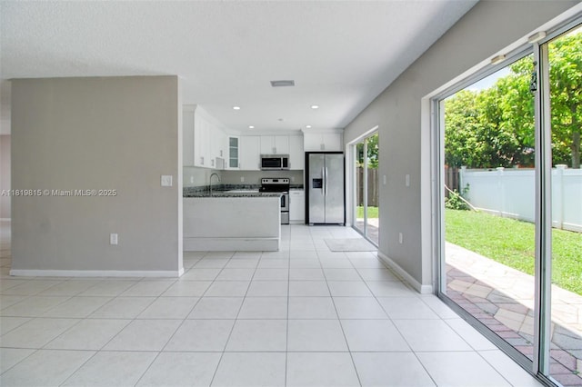 9741 SW 12th St, Pembroke Pines, FL 33025 - kitchen featuring appliances with stainless steel finishes, glass insert cabinets, white cabinets, light tile patterned floors, and recessed lighting